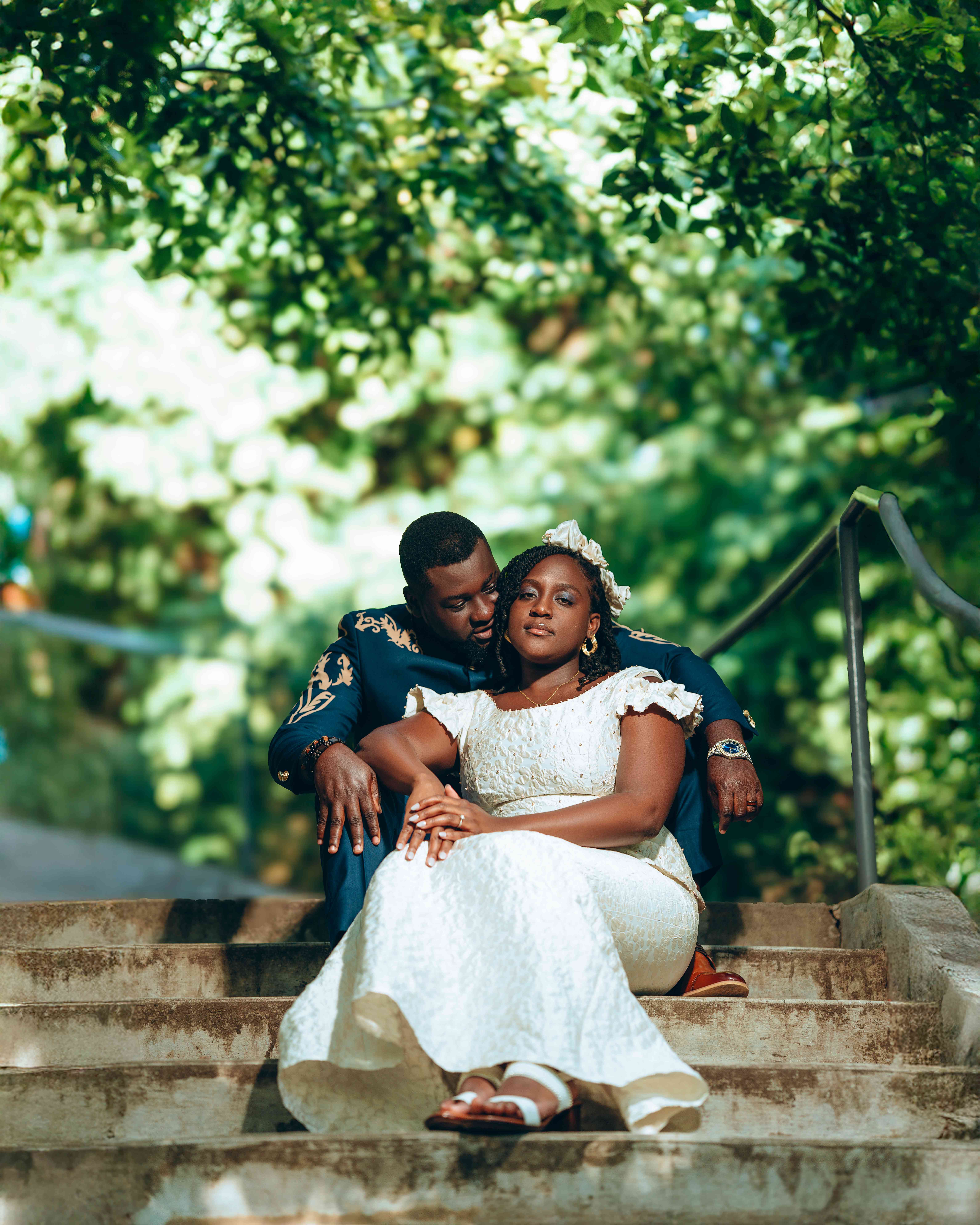 Couple sitting on stone steps in wedding attire
